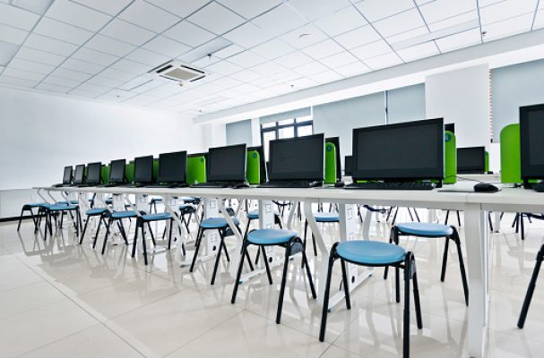 Empty computer training classroom with desks and chairs.